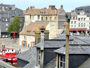 uitzicht op een stad met gebouwen en daken bij Les 4 saisons Honfleur - Studio 2 in Honfleur