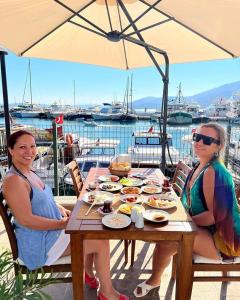 two women sitting at a table with food on it at Caglayan pansiyon in Bodrum City
