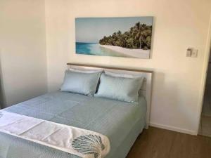 a bedroom with a bed with a painting on the wall at Hervey Bay Shelly Beach Stay ,Pet Friendly 300m to beach in Torquay