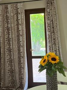 wazę wypełnioną słonecznikami siedzącą przed oknem w obiekcie Villa Rosa Augusta w mieście Camerano