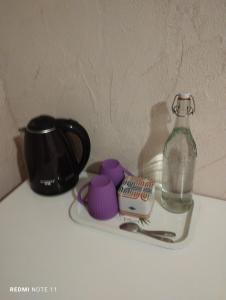 a bottle of water and a cup on a table at Chambre d hôtes en Provence, au pied du Luberon, les Coquelicots in La Tour-dʼAigues