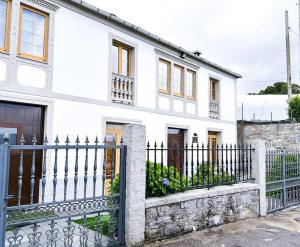 una casa blanca con una valla negra en Casa Arturo, en Triacastela