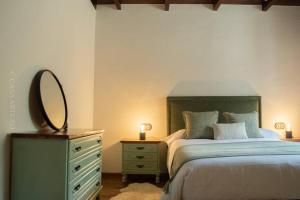 a bedroom with a bed with a mirror and a dresser at Casa Arturo in Treacastela