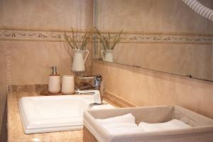 W łazience znajduje się biała umywalka i lustro. w obiekcie Casa Arturo w mieście Triacastela