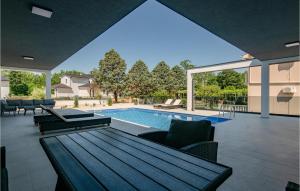 un patio con mesa y sillas y una piscina en 3 Bedroom Nice Home In Nedescina, en Nedeščina