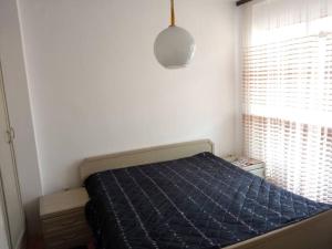 een slaapkamer met een bed met een blauw dekbed en een raam bij Maria's Place in Bitola
