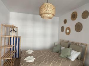 - une chambre avec un lit et un lustre dans l'établissement Apartament Spokojna Przystań, à Rowy