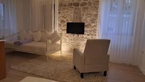 a living room with a couch and a chair at Medulić Palace Rooms & Apartments in Šibenik