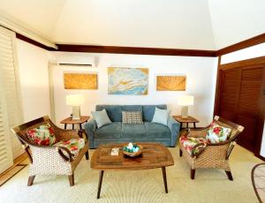 a living room with a blue couch and two chairs at KP40 1Br Poipu Corner Condo with AC, Steps to the Beach in Koloa