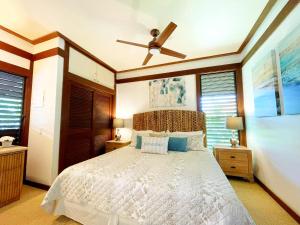 una camera con letto e ventilatore a soffitto di KP40 1Br Poipu Corner Condo with AC, Steps to the Beach a Koloa
