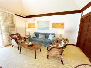 a living room with a blue couch and chairs at KP40 1Br Poipu Corner Condo with AC, Steps to the Beach in Koloa