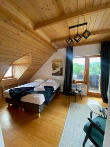 una camera con un grande letto in una stanza con soffitti in legno di Michałówka na Kubalowej Łące a Szczyrk
