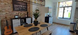 a room with a wooden table and a brick wall at Le Brooklyn Superbe appartement proximité vieille ville in Boulogne-sur-Mer