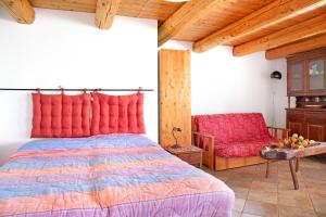 a bedroom with a large bed and a chair at Genzianella Tano di Grich in Cesani