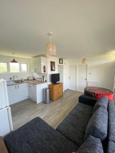 a living room with a couch and a kitchen at Selsey Country Club Valencia Chalet in Selsey
