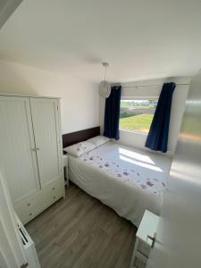 a bedroom with a bed and a window at Selsey Country Club Valencia Chalet in Selsey