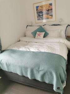 - un lit avec une couverture bleue dans l'établissement Beach front appartments in design eco-villa, à Ulstein