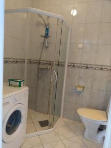 a bathroom with a shower and a washing machine at 1St Floor Oasis - Parking/WiFi in Stavanger +6 photos