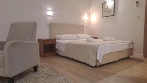 - une chambre avec un lit et une chaise dans l'établissement Medulić Palace Rooms & Apartments, à Šibenik
