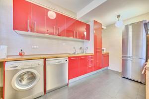 a kitchen with red cabinets and a washing machine at Apartamento la Laurel by Clabao in Logroño