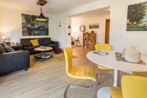 sala de estar con mesa y sillas amarillas en Haus Auryn en Markelfingen