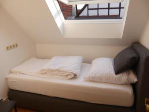 - un lit avec des draps et des oreillers blancs dans l'établissement Ferienhaus Baarsen 30, à Bad Pyrmont