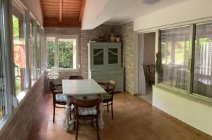 a dining room with a table and chairs and windows at Helena Vendégház in Siófok