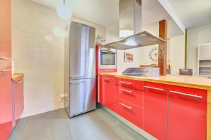 a kitchen with red cabinets and a stainless steel refrigerator at Apartamento la Laurel by Clabao in Logroño