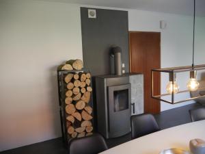 a living room with a fireplace and a pile of logs at Ferienhaus Baarsen 30 in Bad Pyrmont