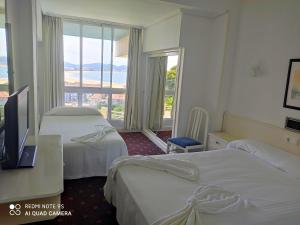 Hotel Miramar Laredo في لاريدو: غرفة فندقية بسريرين ونافذة كبيرة