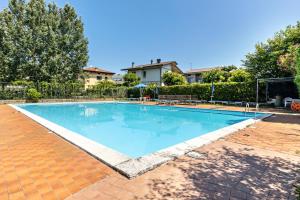 una gran piscina en un patio con una casa en Casa Cattaleya, en Desenzano del Garda