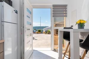 eine Küche mit einem Tisch und eine Tür, die auf eine Terrasse führt in der Unterkunft Apartment Matea in Trogir
