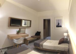 a bedroom with a bed and a desk and a tv at Gorgona Hotel in Skála Sykaminéas