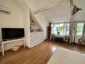 uma sala de estar com uma televisão de ecrã plano na parede em Suite privative dans maison de caractère em Le Faou