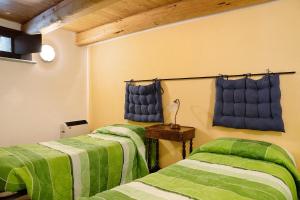 duas camas num quarto com lençóis verdes em Arnica Tano di Grich em Cesani