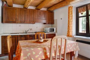 uma cozinha com uma mesa com cadeiras e um micro-ondas em Arnica Tano di Grich em Cesani