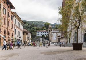 a group of people walking around a city street at Bonnes Vacances a Pietrasanta in Pietrasanta