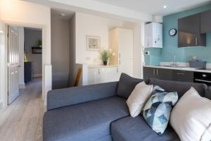 een woonkamer met een blauwe bank en een keuken bij The Old Stables in Southampton