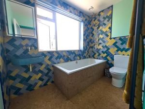 ein Badezimmer mit Badewanne und Toilette und einem Fenster in der Unterkunft Aqua Cottage in Combe Martin + 21 Fotos