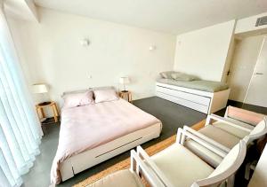 1 Schlafzimmer mit 2 Betten, 2 Stühlen und einem Spiegel in der Unterkunft Troia Garden View Apartment in Troia + 20 Fotos