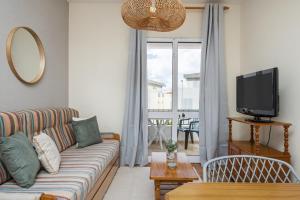 a living room with a couch and a tv at Escapadinha do Sol by Homie in Pontinhas