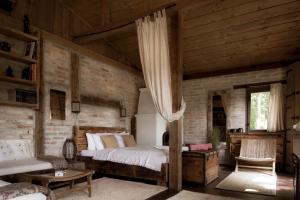 1 dormitorio con 1 cama y pared de madera en Naphegy vendégház, en Zebegény