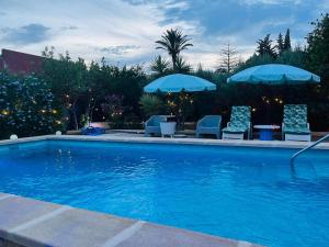 basen z 2 parasolami i krzesłami oraz stołem i krzesłami w obiekcie Chalet con piscina privada Cortijo Indalo VTAR/AL/00447 w mieście Pechina