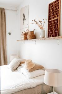 a bedroom with a white bed with two shelves at BijBlauw in Willemstad