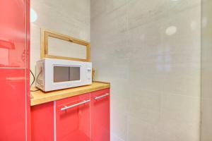 a small kitchen with a microwave and red cabinets at Apartamento la Laurel by Clabao in Logroño +26 photos