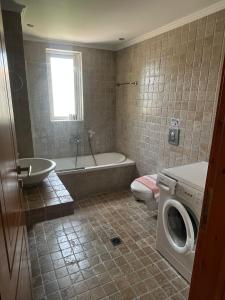 La salle de bains est pourvue d'une baignoire et d'un lave-linge. dans l'établissement Santa Emelia, à Vasiliki