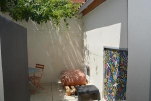 un patio con un tavolo e una valigia accanto a un muro di Maison Rascas - Centre historique - Air conditioning- wifi ad Avignone