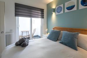 een slaapkamer met een bed met blauwe kussens en een raam bij The Old Stables in Southampton