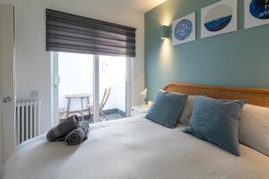 a bedroom with a bed with blue pillows and a window at The Old Stables in Southampton