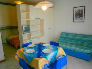 a room with a blue table and a bed at Villaggio dei Fiori - Agenzia Cocal in Caorle